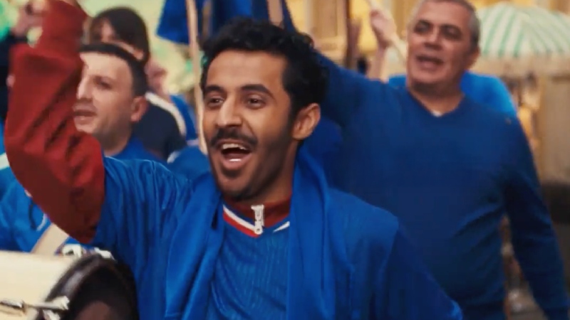 Football fans celebrating enthusiastically in team colors during a match-day street celebration.